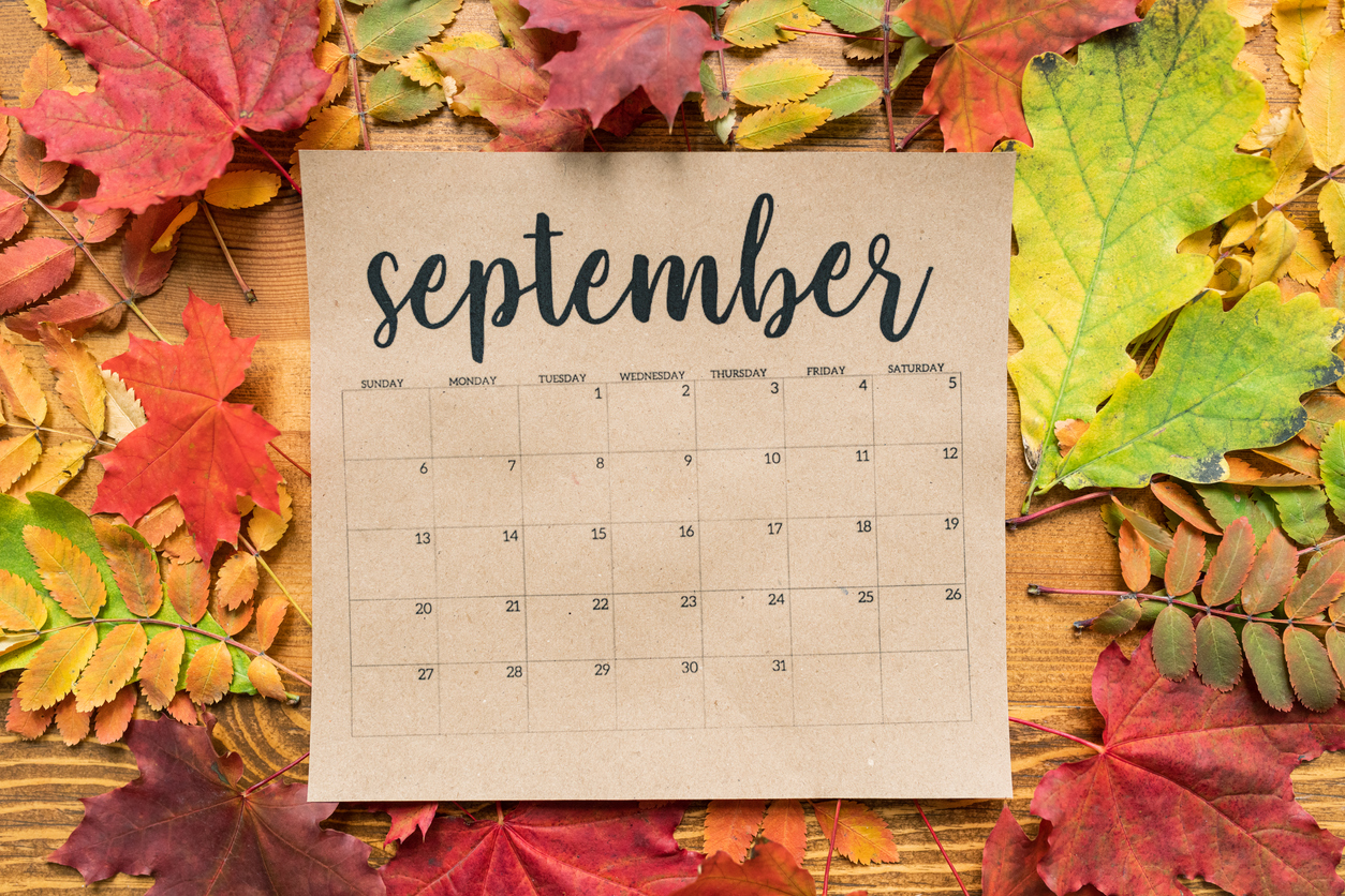 September calendar page with colorful leaves in the background