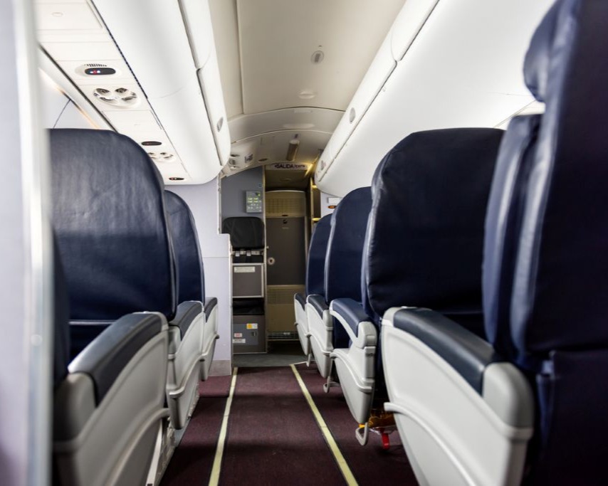 view down airplane aisle with empty seats on each side